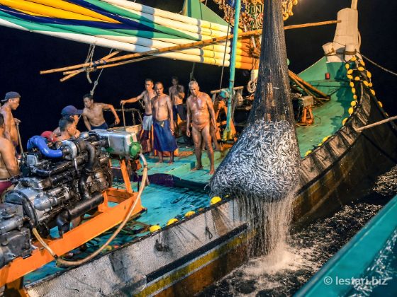 Fishermen hauling the catch at sea